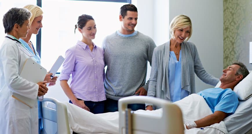 A doctor checking in with a patient resting comfortably in a hospital bed